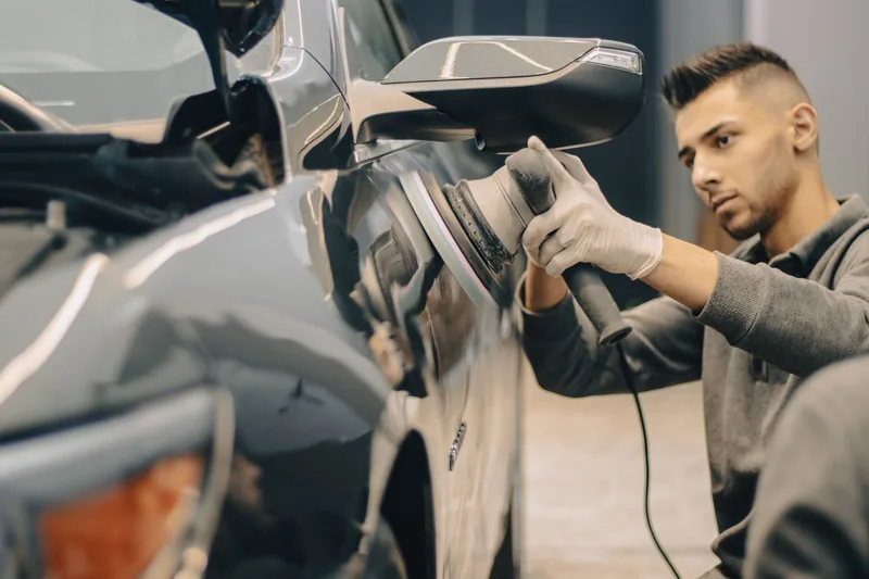 Detailer buffing a car panel for a mirror finish