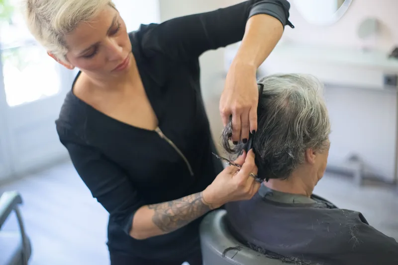 Stylist trimming a customer's hair with scissors