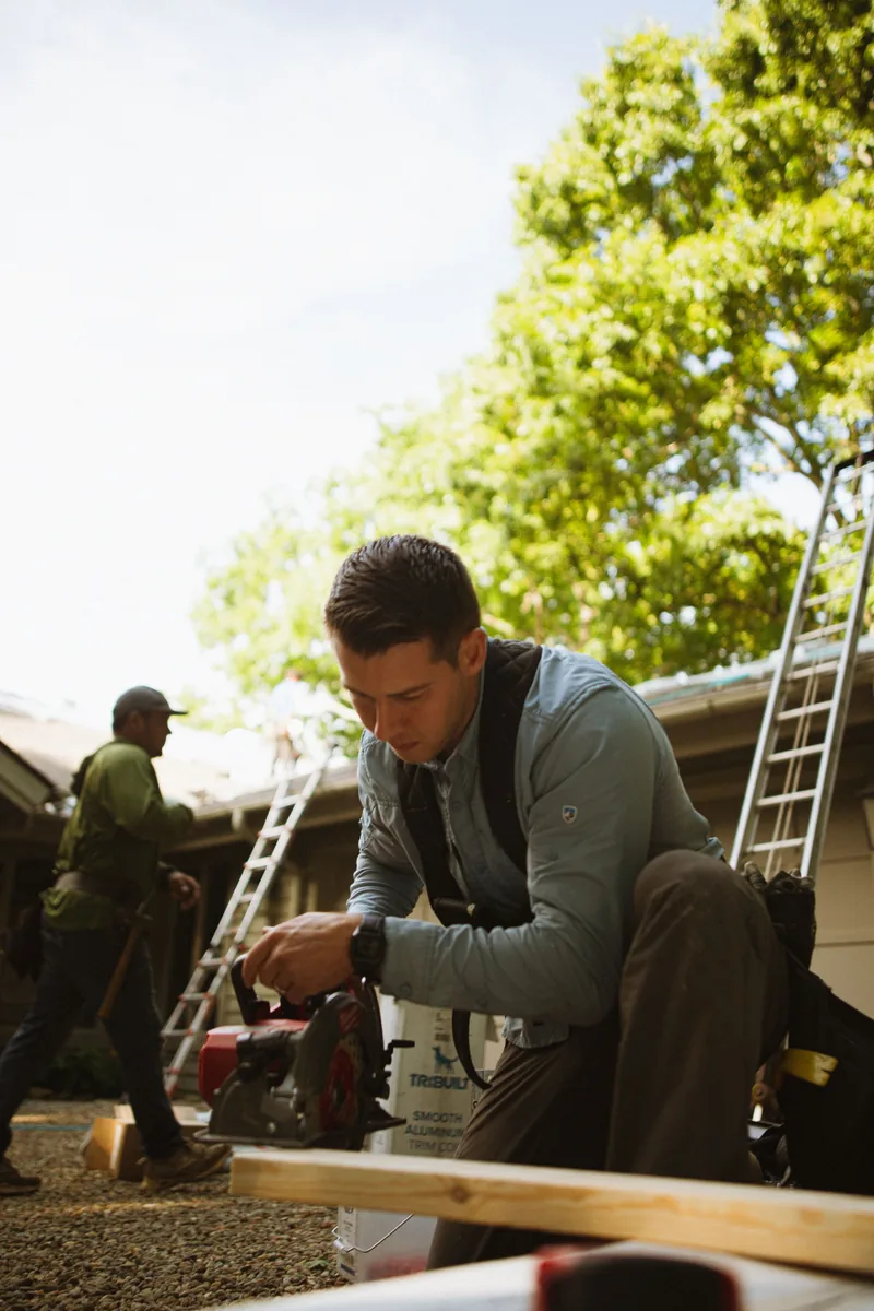 Builder working with tools at an outdoor job site