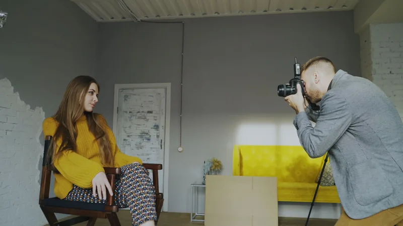 Photographer capturing a seated woman in a studio session