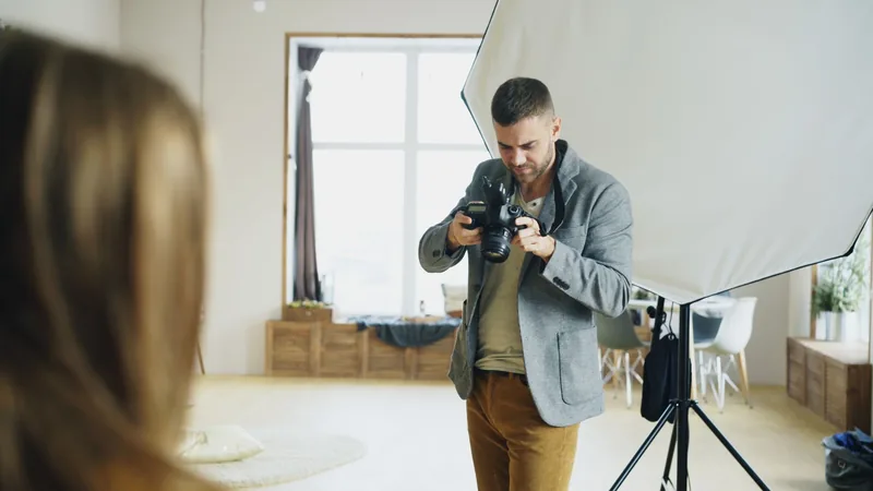 Photographer setting up a portrait shot in a bright studio