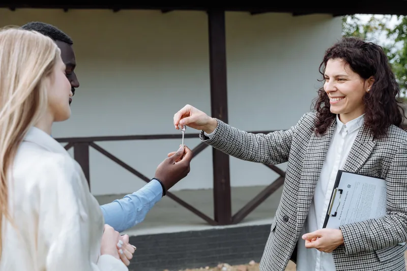 Real estate agent handing keys to happy new owners