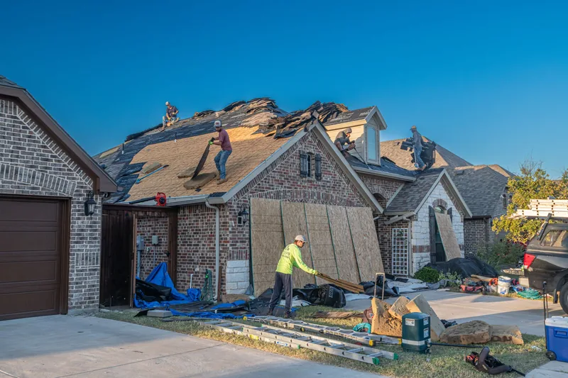 Roofing crew replacing the roof of a brick home